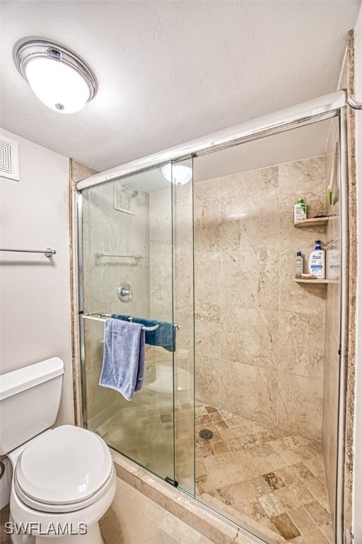 bathroom featuring an enclosed shower and toilet