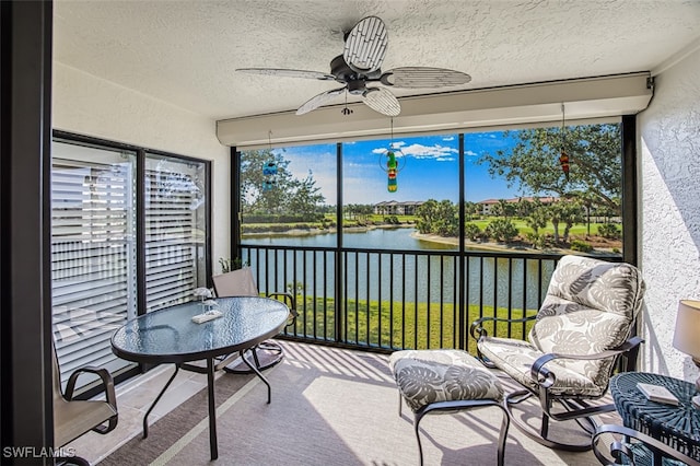 sunroom / solarium with a water view and ceiling fan