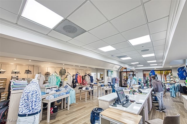 exercise room with light hardwood / wood-style floors and a drop ceiling