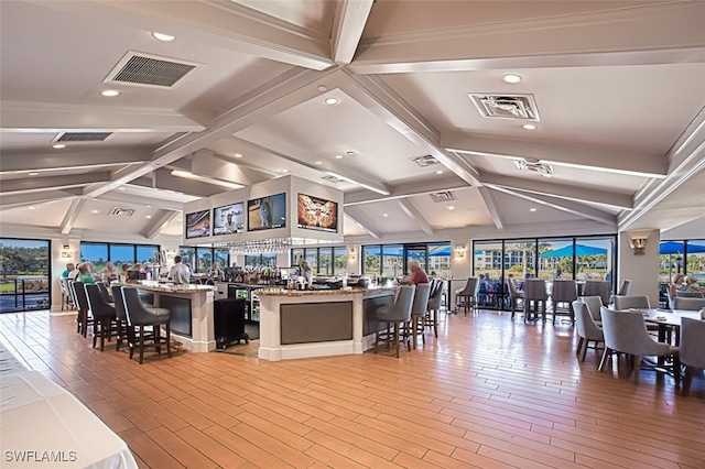 interior space featuring lofted ceiling with beams, plenty of natural light, and light wood-type flooring