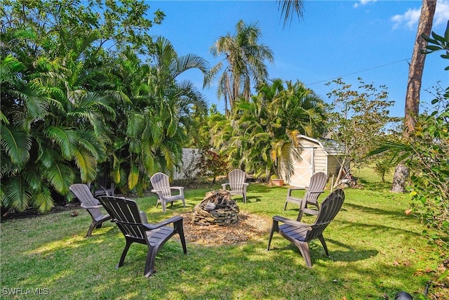 view of yard featuring a storage shed, an outdoor fire pit, and an outdoor structure