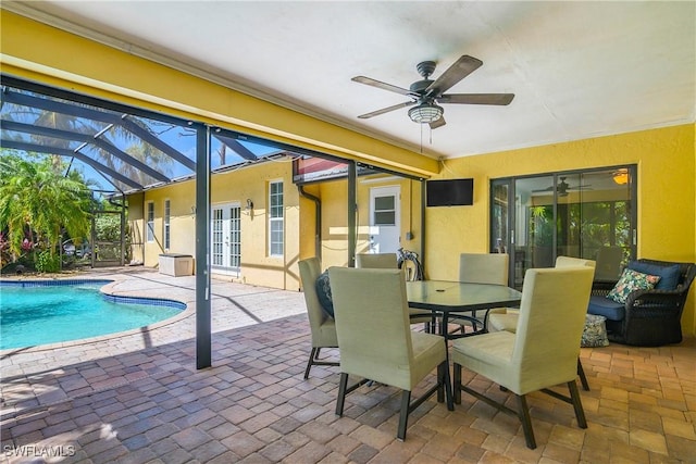 exterior space with a patio area, ceiling fan, glass enclosure, and french doors