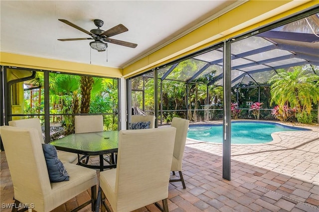 outdoor pool featuring ceiling fan, a patio, outdoor dining space, and glass enclosure