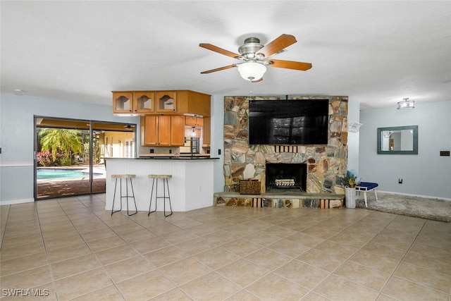 23250 El Dorado Blvd, Bonita Springs, FL 34134 - living area featuring light tile patterned floors, ceiling fan, baseboards, and a fireplace