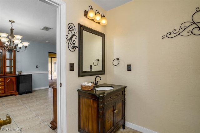 bathroom with baseboards, visible vents, tile patterned floors, vanity, and a chandelier