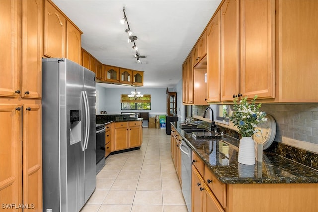 kitchen featuring light tile patterned floors, stainless steel appliances, a peninsula, a sink, and tasteful backsplash