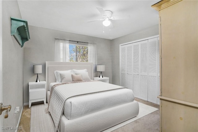 bedroom with a ceiling fan, a closet, light colored carpet, and baseboards