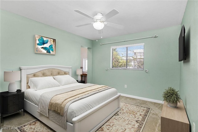 bedroom featuring baseboards, a ceiling fan, and light colored carpet