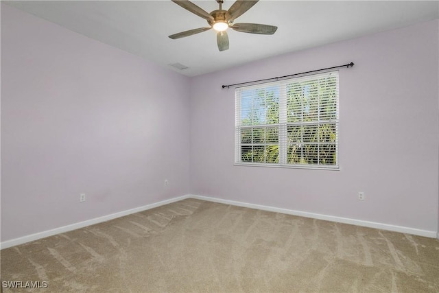 empty room featuring carpet floors, visible vents, ceiling fan, and baseboards