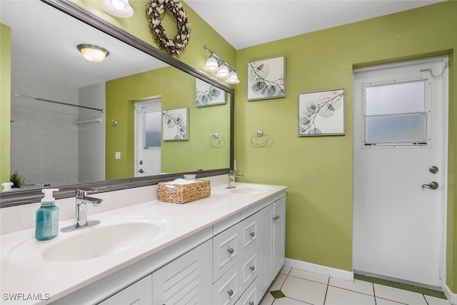 bathroom featuring double vanity, baseboards, a sink, and tile patterned floors