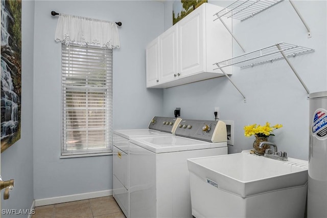 laundry room featuring light tile patterned flooring, separate washer and dryer, a sink, baseboards, and cabinet space