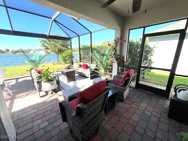 sunroom with a water view and ceiling fan