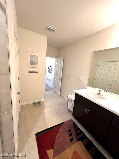 bathroom featuring tile patterned floors, visible vents, baseboards, and vanity