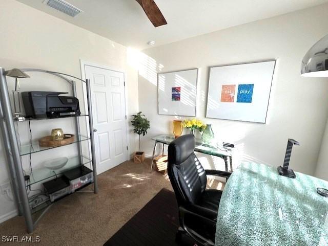 office area with visible vents, carpet, and ceiling fan