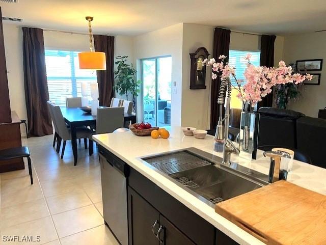 kitchen featuring dishwasher, light countertops, light tile patterned floors, and pendant lighting