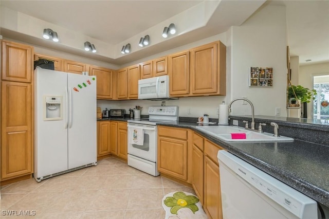 kitchen featuring dark stone countertops, sink, white appliances, and light tile patterned flooring