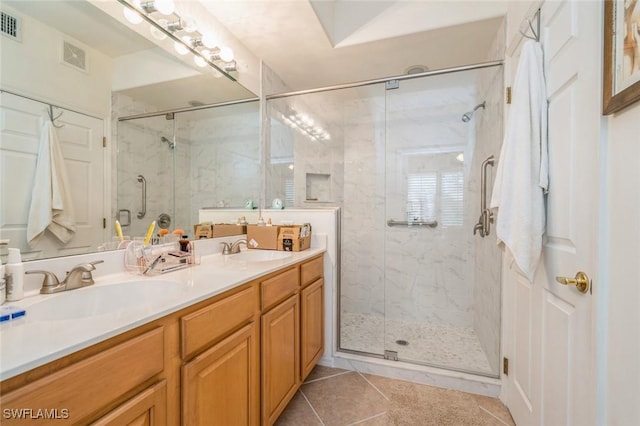 bathroom with vanity, a shower with shower door, and tile patterned floors