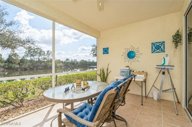 sunroom featuring a water view and ceiling fan