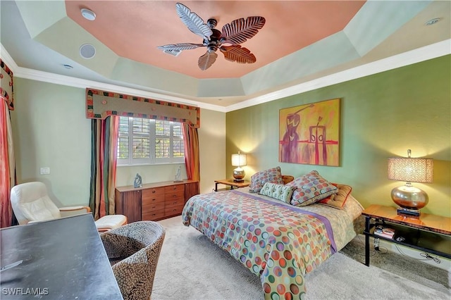 bedroom featuring crown molding, carpet flooring, a tray ceiling, and ceiling fan