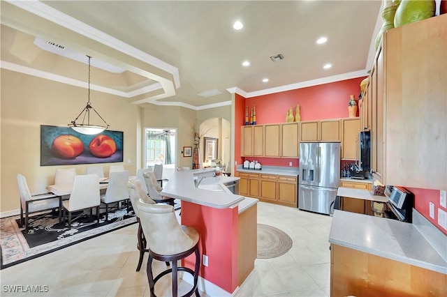 kitchen with pendant lighting, an island with sink, a kitchen bar, ornamental molding, and stainless steel appliances