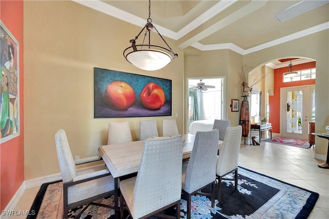 tiled dining room with a towering ceiling and ornamental molding