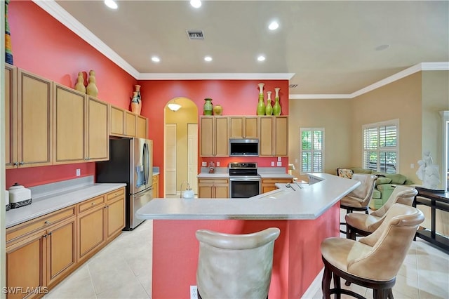 kitchen featuring a large island, ornamental molding, a kitchen breakfast bar, and appliances with stainless steel finishes