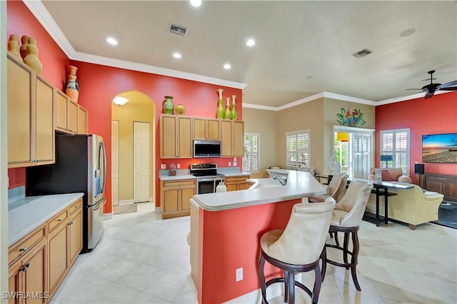 kitchen featuring stainless steel appliances, plenty of natural light, a center island with sink, and a kitchen bar