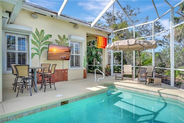 view of pool with a patio and glass enclosure