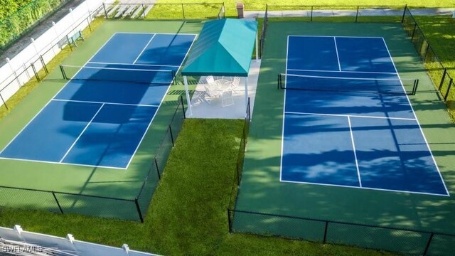 view of tennis court with a yard