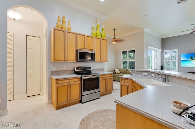 kitchen featuring appliances with stainless steel finishes, a sink, light countertops, light tile patterned floors, and crown molding