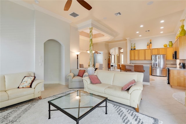 living area with arched walkways, a ceiling fan, ornamental molding, recessed lighting, and light tile patterned flooring