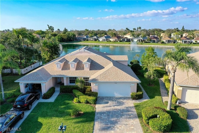 exterior space with a garage, a front yard, and a water view