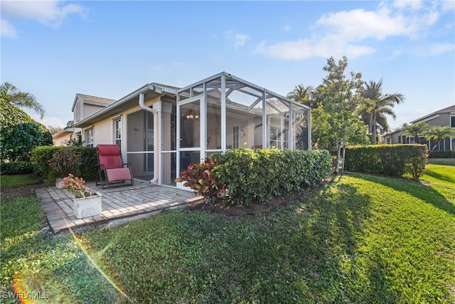 rear view of house featuring a yard, a lanai, and a patio area