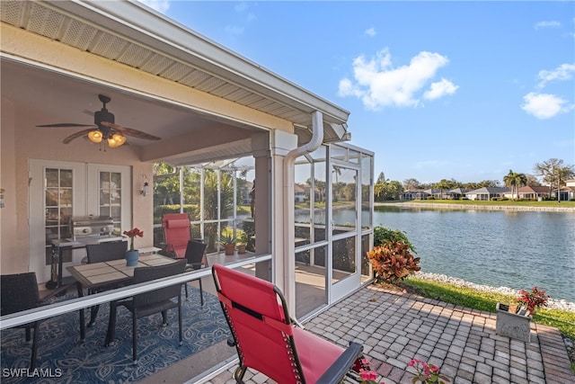 view of patio / terrace featuring a water view, area for grilling, and ceiling fan