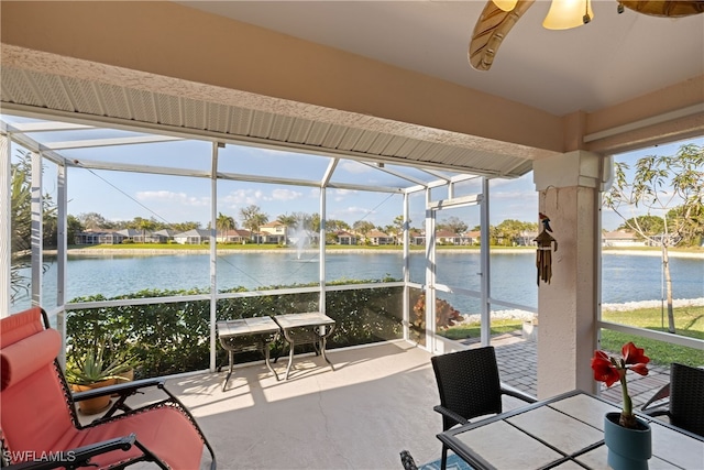 sunroom / solarium featuring a water view and ceiling fan