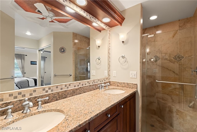 bathroom with ceiling fan, vanity, a shower with shower door, and backsplash