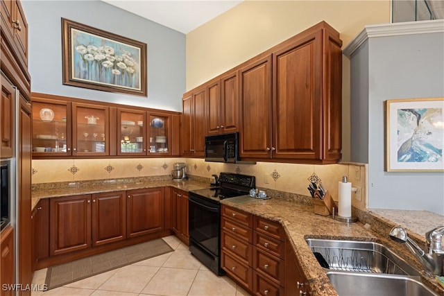 kitchen with sink, light stone counters, black appliances, light tile patterned flooring, and decorative backsplash