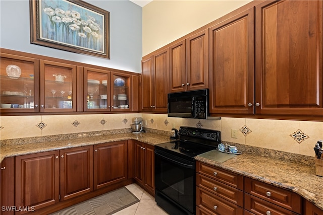 kitchen featuring light stone counters, tasteful backsplash, black appliances, and light tile patterned flooring