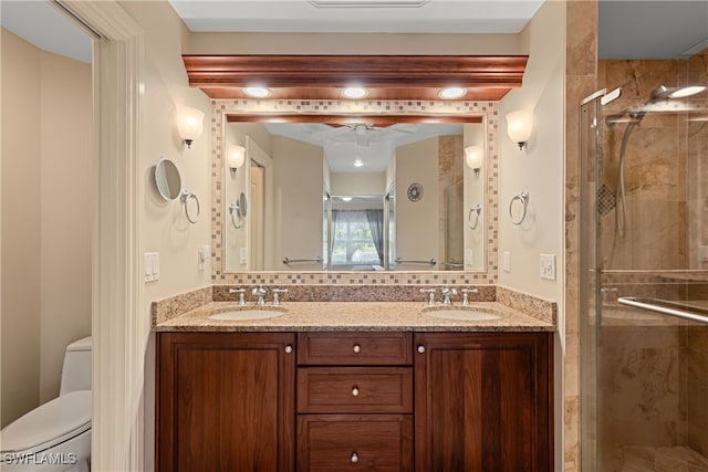 bathroom featuring a shower with door, vanity, and toilet