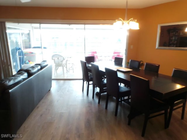 dining area featuring hardwood / wood-style floors and an inviting chandelier