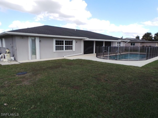 rear view of property with a patio, a fenced in pool, and a lawn