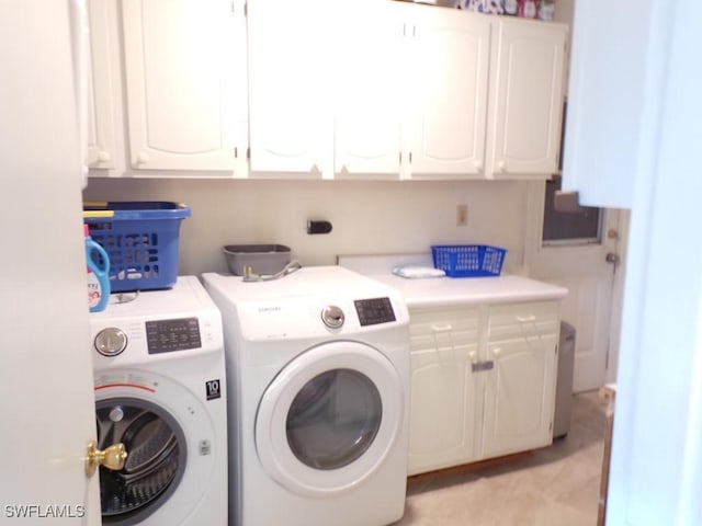 washroom with cabinets and washing machine and dryer