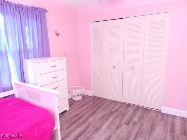 unfurnished bedroom with light wood-type flooring and a closet