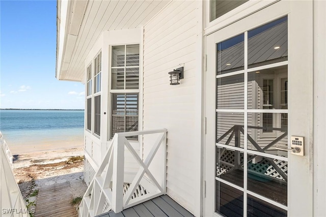 balcony featuring a view of the beach and a water view