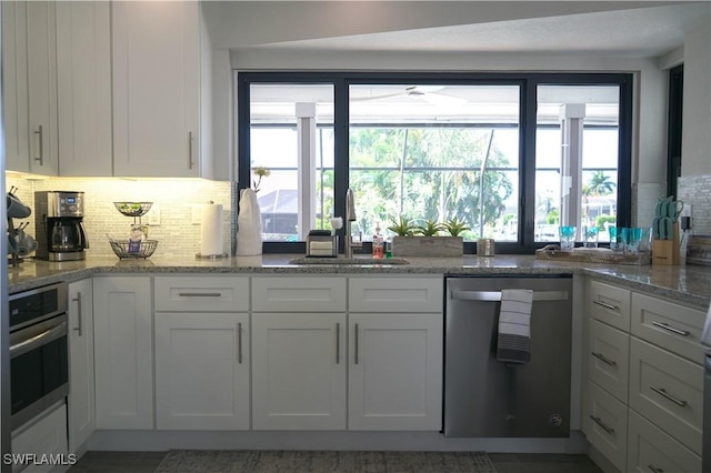 kitchen with stainless steel appliances, sink, and white cabinets