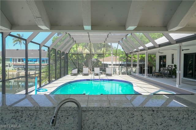 view of swimming pool featuring a lanai, a patio, and ceiling fan