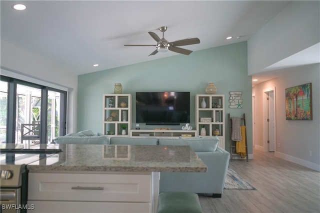 living room with vaulted ceiling, ceiling fan, and light hardwood / wood-style flooring