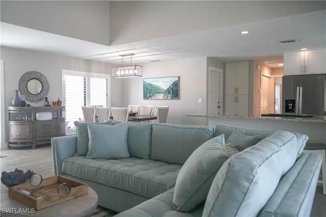 living room with a notable chandelier and light wood-type flooring