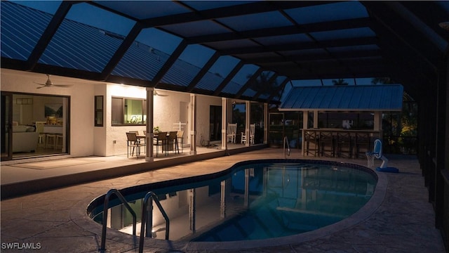 view of pool featuring a patio area, an outdoor bar, ceiling fan, and glass enclosure