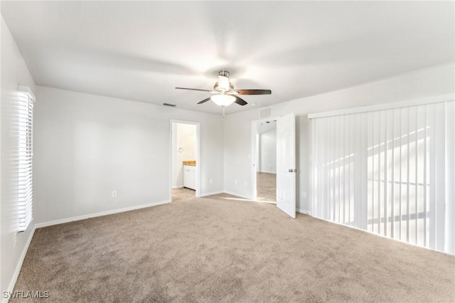 unfurnished bedroom featuring visible vents, baseboards, ensuite bathroom, and light colored carpet